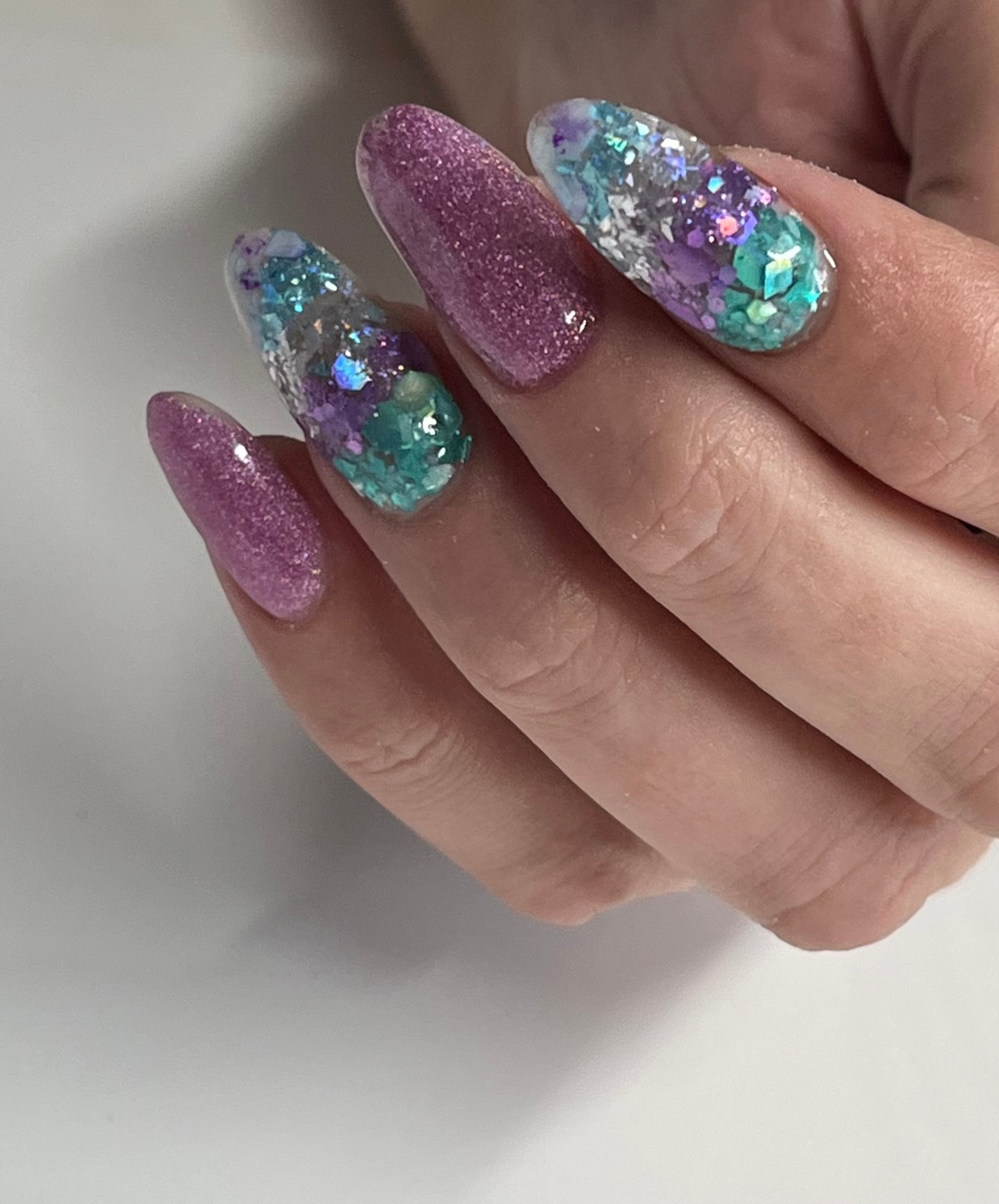 Pink glitter almond nails with iridescent flakes accent