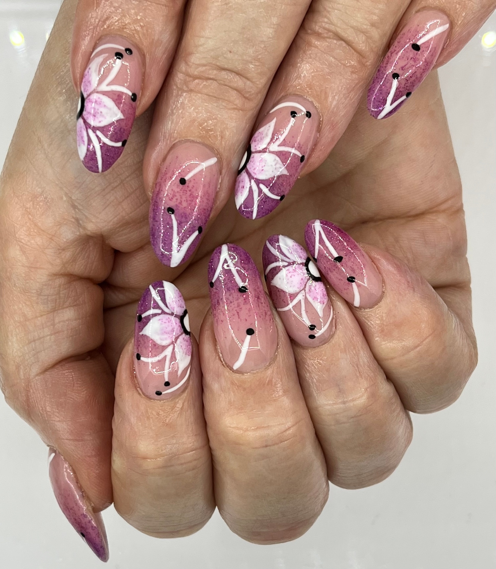 Almond nails with pink ombré and painted white lilies